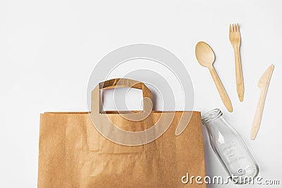Brown Kraft paper grocery shopping bag wooden flatware cutlery on white background. Plastic-free alternatives zero waste Stock Photo