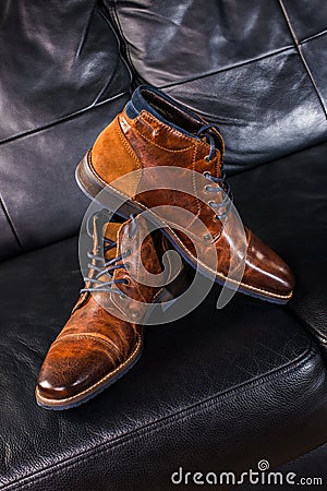 Brown Leather shoes displayed on black leather sofa Stock Photo
