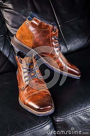 Brown Leather shoes displayed on black leather sofa Stock Photo