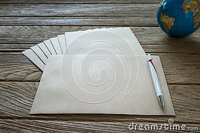 Brown Letter Envelop with globe and pen on wooden table Stock Photo
