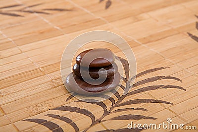 Brown massage stones composition on bamboo placemat Stock Photo