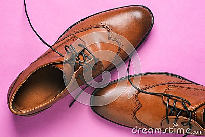 Brown men`s shoes close-up. Classic shoes with untied laces on a pink background. Shoes for weddings, everyday walking Stock Photo