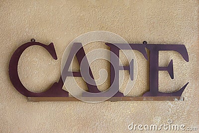 Brown Metal Cafe Sign against a Textured Wall Stock Photo