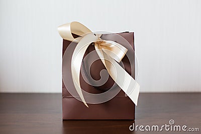 Brown pack tied up with beige bow. Stock Photo