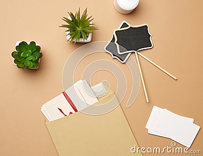 Brown paper envelope and empty wooden pointer on a brown background Stock Photo