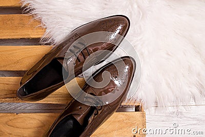 Brown patent leather shoes on a pallet, white fur. Fashionable concept Stock Photo