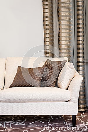 Brown pillows on empty beige sofa Stock Photo