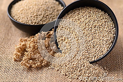 Brown quinoa seeds in a bowl and pouring Stock Photo