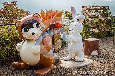 Brown raccoon and white rabbit statue at Kachi Kachi ropeway viewpoint, Japan. Editorial Stock Photo