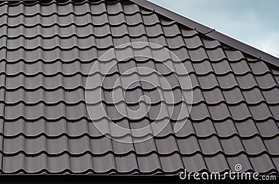 Brown roof tiles or shingles on house as background image. New overlapping brown classic style roofing material texture pattern o Stock Photo