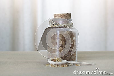 Brown sugar in glass bottle and wooden spoon Stock Photo
