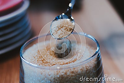 Brown sugar in spoon and dishware on napkin Stock Photo