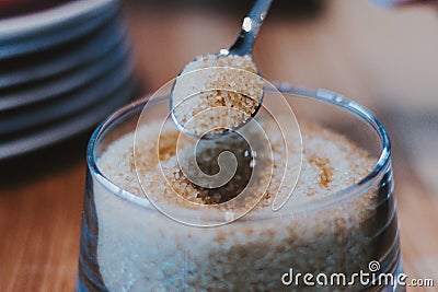 Brown sugar in spoon and dishware on napkin Stock Photo