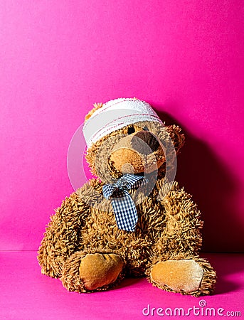 Brown teddy bear with bandage at the head at pediatrician Stock Photo
