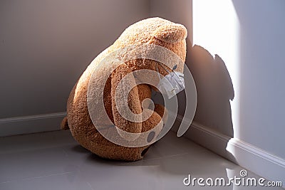 The brown teddy bear looked sad and disappointed inside the house. Stock Photo