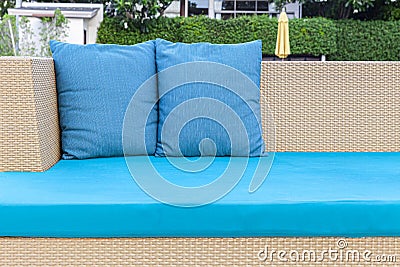 brown wicker sofa and blue cushions and cushions placed on the lawn Stock Photo