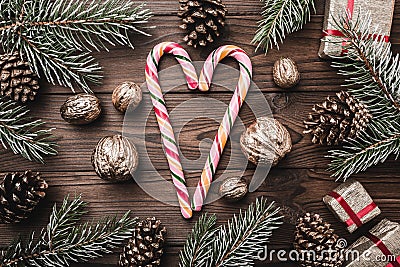 Brown wood background. Fir branches, cones and decorative walnuts. Colorful candies. Gifts for xmas. Stock Photo