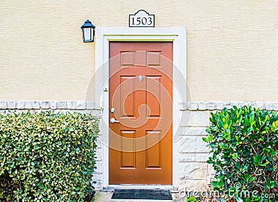 Brown wooden door near green hedges Editorial Stock Photo