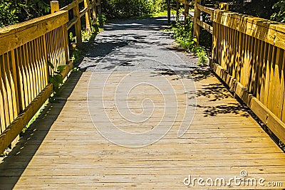 Brown wooden fence paved bridge walking trail distant view Georgia USA Stock Photo