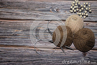 brown yarn on wooden textured background and two crochet.needle Stock Photo