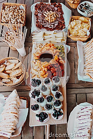 Brunch. Appetizers table with cheese, chips, bread, sandwiches, yogurt, fruits chocolate fondue tangerine, banana, kiwi, Stock Photo