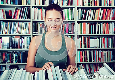 Brunete girl chooses a book in university library Stock Photo