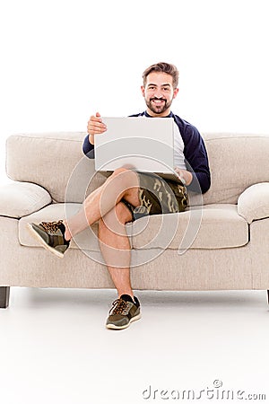 Brunette beardy man sitting on sofa. Stock Photo