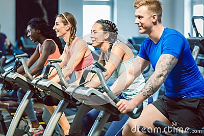 Side view of a beautiful woman smiling while cycling at the gym Stock Photo