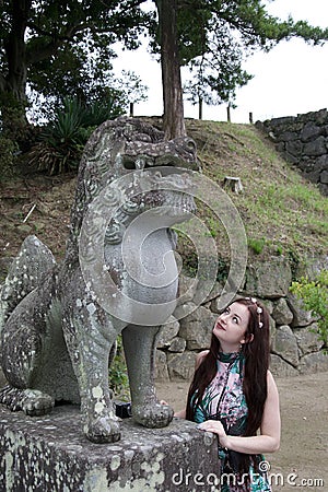 Brunette caucasian hippie girl admiring ancient damaged Japanese statue Stock Photo