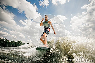 Brunette caucasian surfer performs his professional abilities Stock Photo