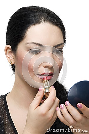 Brunette female applying lipstick in mirror Stock Photo