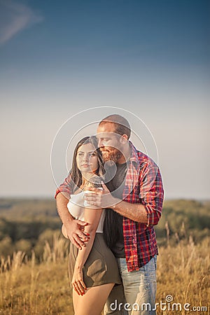 Brunette girl and brutal guy with a beard love story. Hugs and Stock Photo