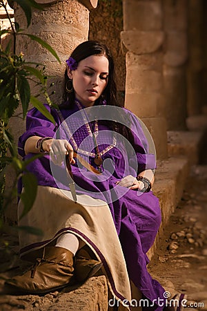 Brunette girl in a medieval suit in a Agia Napa Medieval Monastery Stock Photo