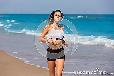 Brunette girl running on the beach headphones Stock Photo
