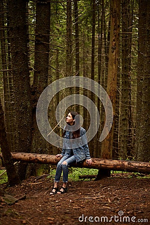 Brunette girl walking on the woods, traveler in romanian carpathian mountains, looking up. Vertical view Stock Photo