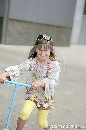 Brunette little girl with scooter in the city Stock Photo