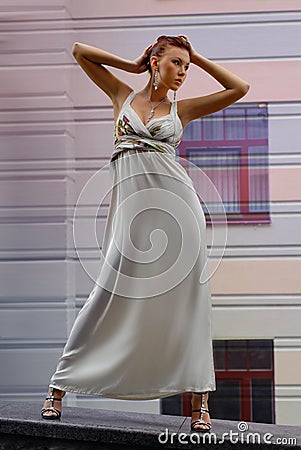 Brunette in long dress near a hotel Stock Photo