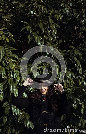 Brunette posing in front of a huge bush Stock Photo