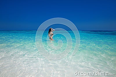 Brunette bikini model posing in sea wave surface, summer ba Stock Photo