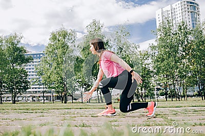 Brunette slim adult sexy fit sporty woman in sportswear on a european city streets in morning do exercises (workout) - Stock Photo