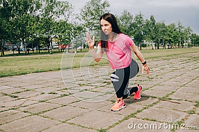 Brunette slim adult sexy fit sporty woman in sportswear on a european city streets in morning do exercises (workout) - Stock Photo