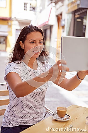 Brunette taking pictures with tablet pc Stock Photo