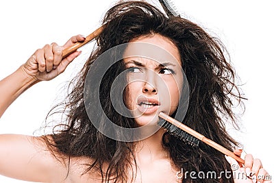 Brunette woman with combs in wavy unruly hair looking away isolated on white Stock Photo