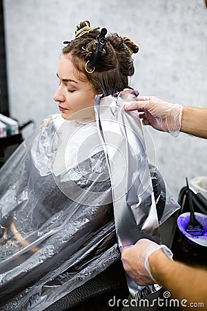 Brunette woman dying her hair at the beauty salon Stock Photo