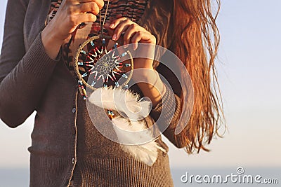 Brunette woman with long hair holding dream catcher Stock Photo