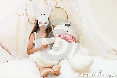 brunette woman with rabbit mask hold big bear Stock Photo