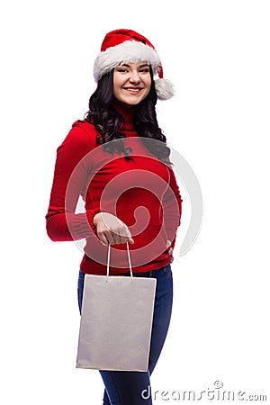 brunette woman wearing christmas hat holding present bag with a happy face. Isolated Stock Photo