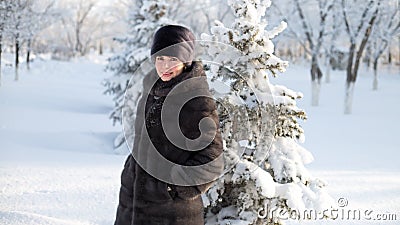 A brunette woman in winter clothes walks through Stock Photo