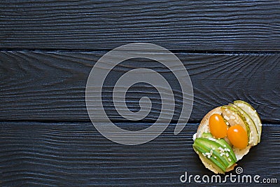 Bruschetta with cheese, parmesan, pear and yellow orange cherries tomatos, avocado with goat cheese on black wooden rustic Stock Photo