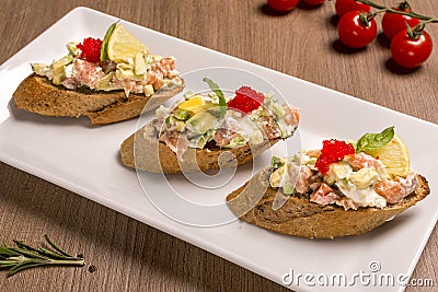 Bruschetta with salmon and avocado dried rye baguette, cream cheese Stock Photo